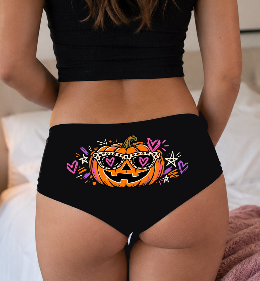 Model in a top wearing black boyshorts with the sunglasses jack-o'-lantern print