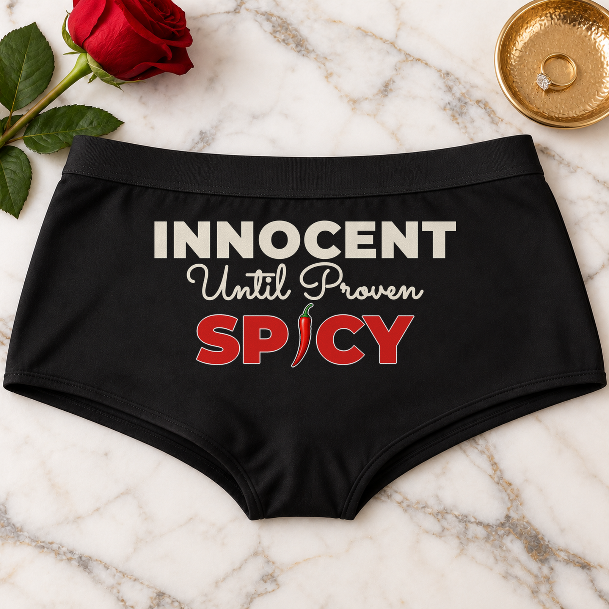 Innocent Until Proven Spicy panties – black boyshort underwear with "Innocent Until Proven Spicy" saying, lifestyle photo