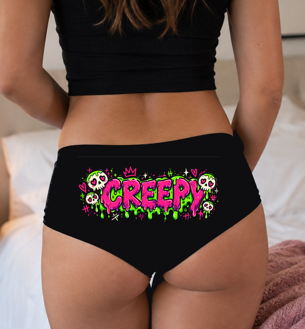 Model in a top wearing black boyshorts with the pink CREEPY slime print