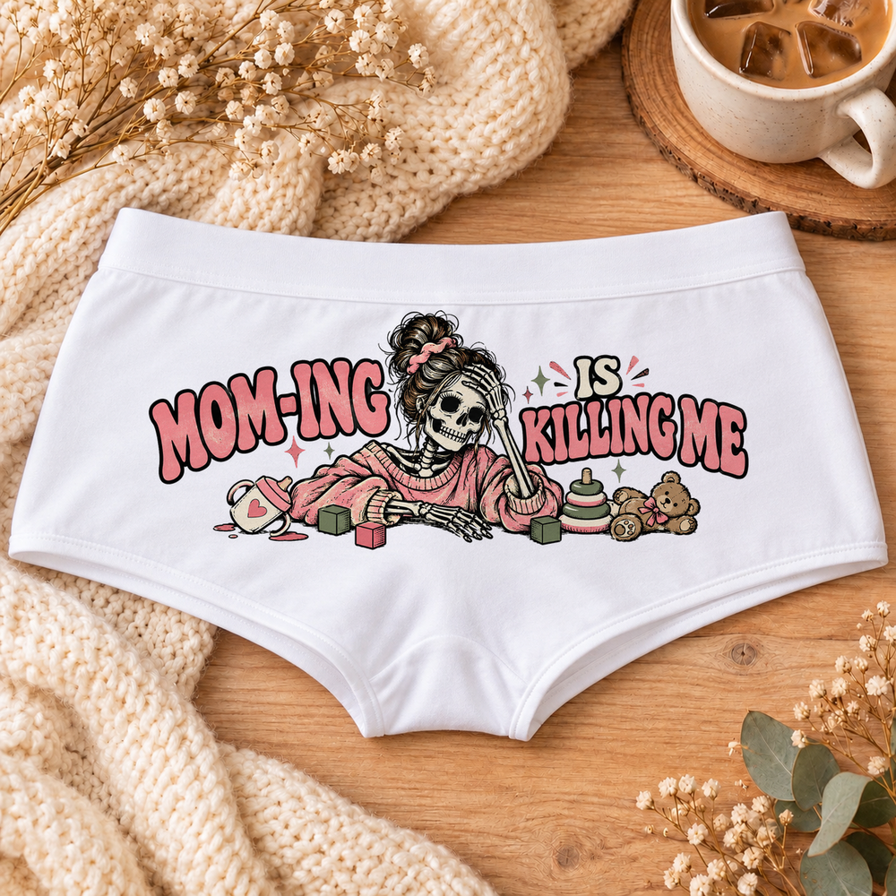 White Mom-ing Is Killing Me funny mom boyshort underwear with a messy-bun skeleton mom in a pink sweater, toys and pink lettering, flat-lay